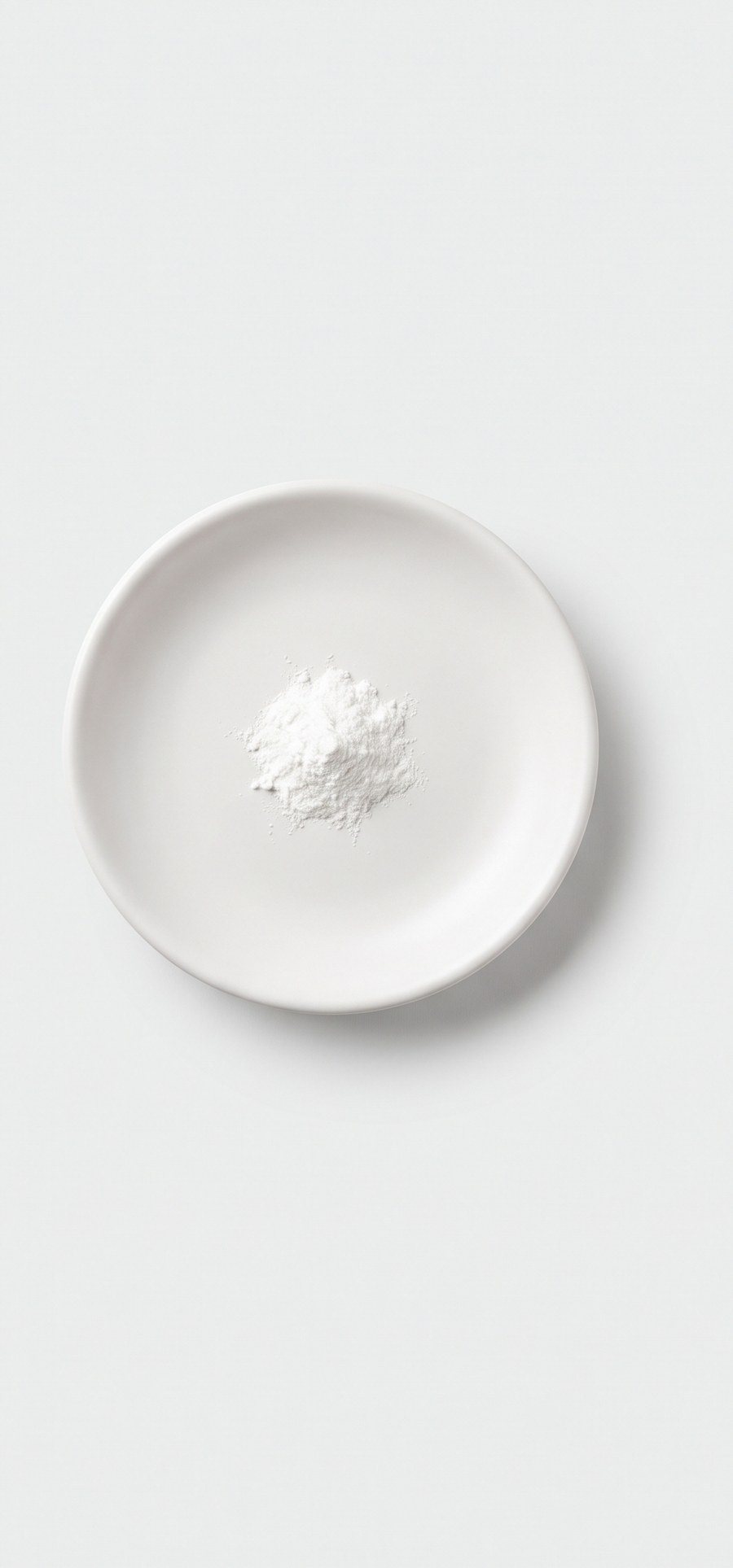 Una pizca de polvo blanco de estearato de magnesio en un platito.